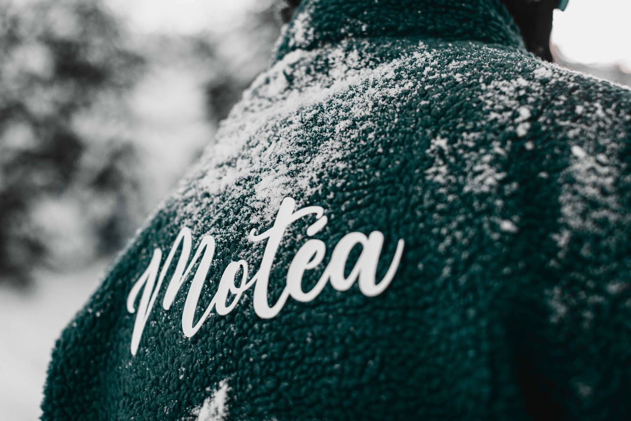 Close-up of a teal jacket with snow and Motéa branding in Brezovica, Serbia.